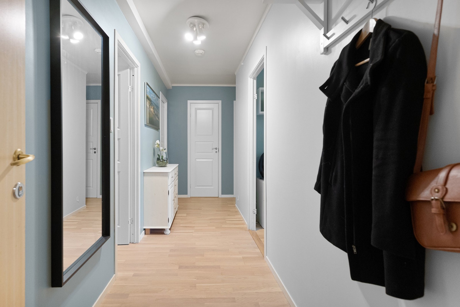 Stor og romslig entré/gang med god plass til oppbevaring av tøy. På enden av gangen har mann innvendig bod som kan innredes som omkledningsrom. Galleribilde