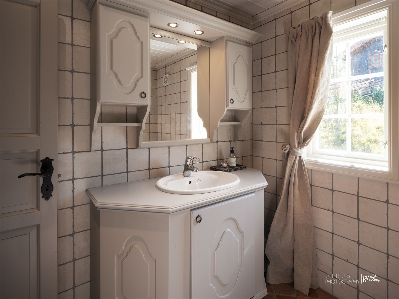 Flislagt gjestebad med dusj, klosett og baderomsinnredning med servant. Galleribilde