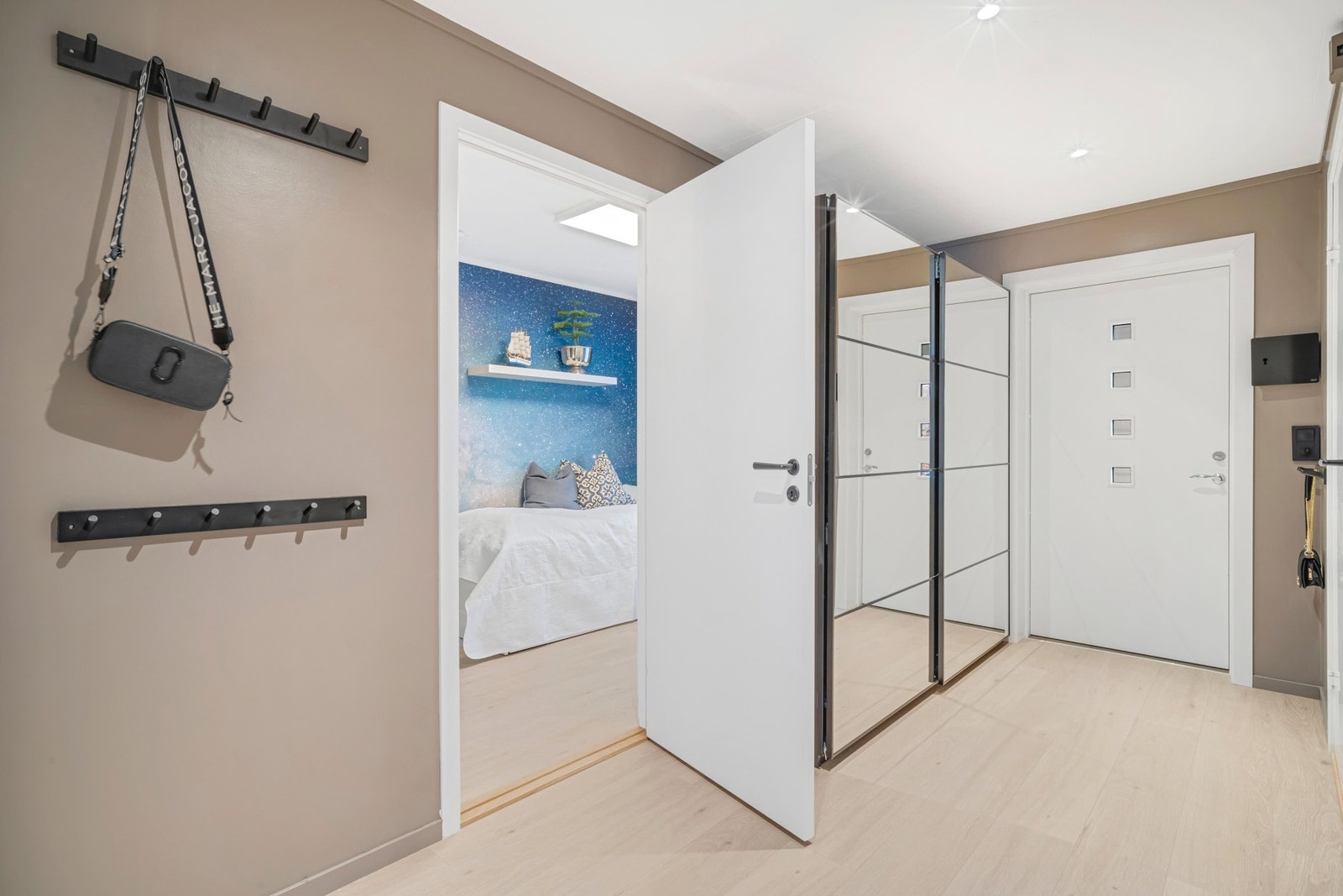 Gang sett mot inngangsparti og skyvedørsgarderobe m/speilfronter. Ny ytterdør i 2022. Galleribilde