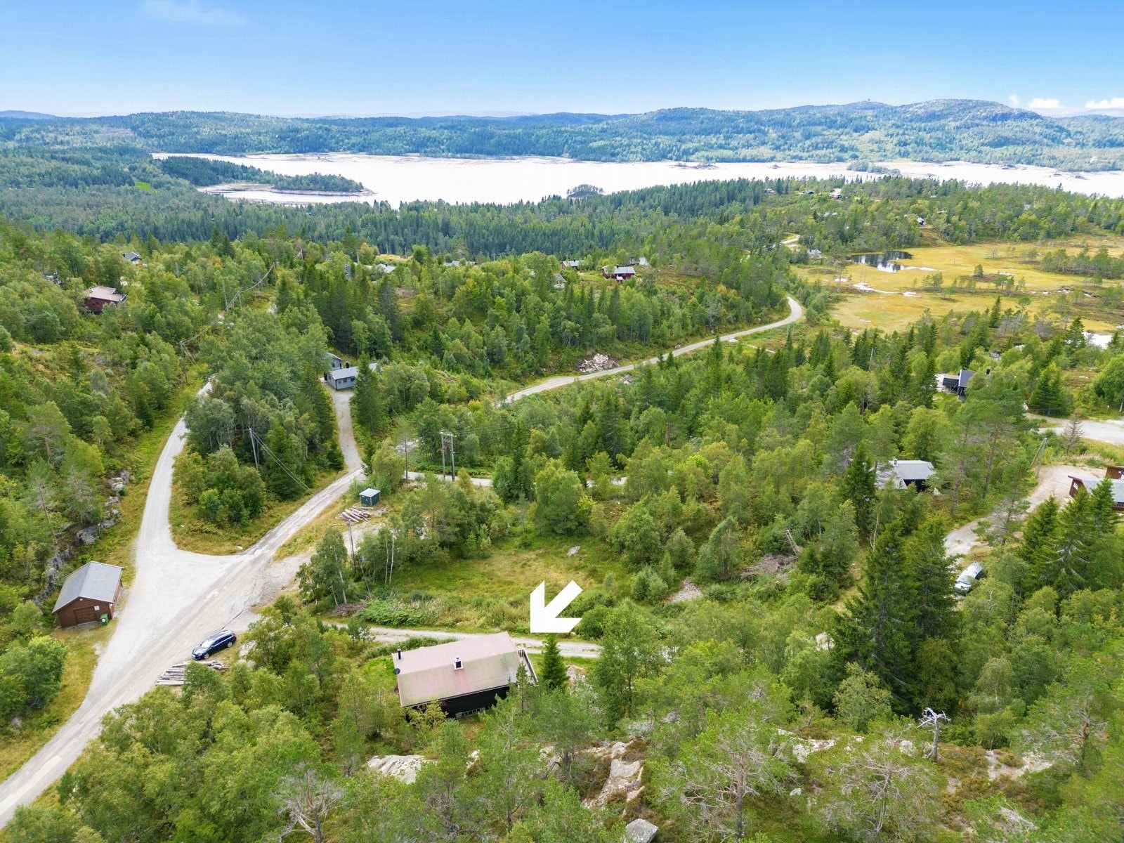 Dronebilde over området med pil mot hytten Galleribilde