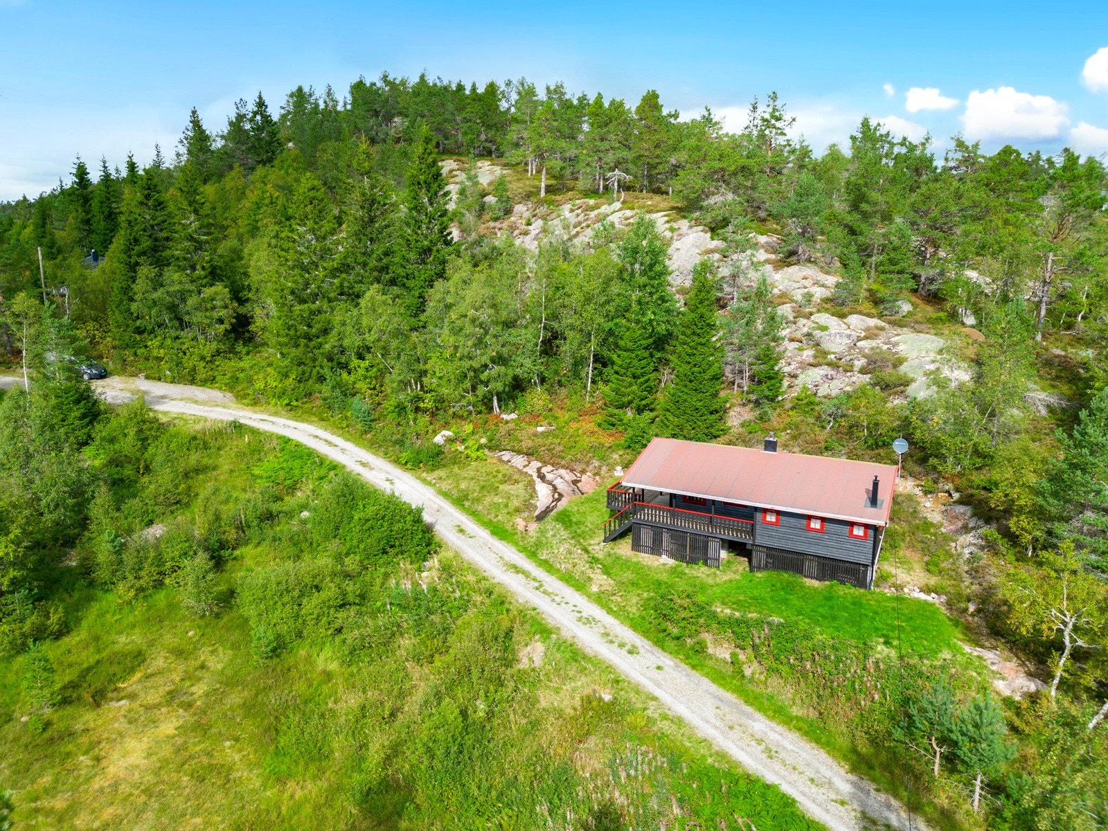 Hytten ligger fint plassert i terrenget i naturskjønne omgivelser Galleribilde