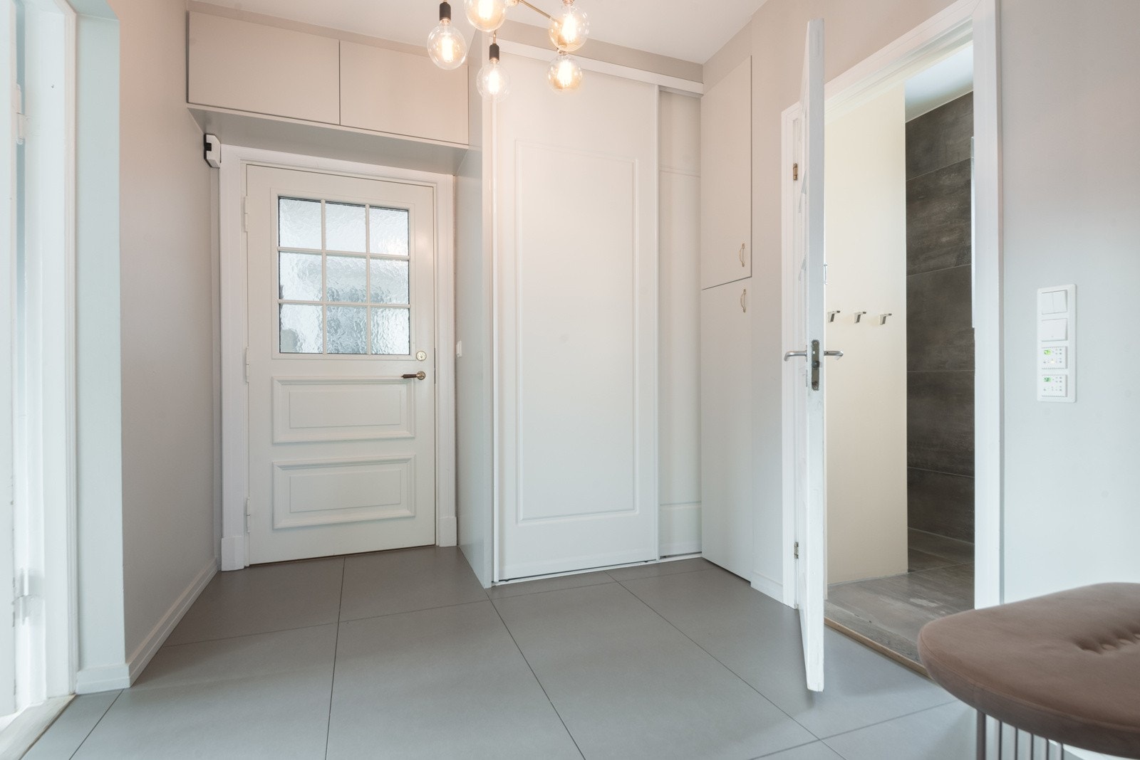 Romslig hall med garderobeplass og direkte inngang til gjeste-bad med dusj og WC Galleribilde