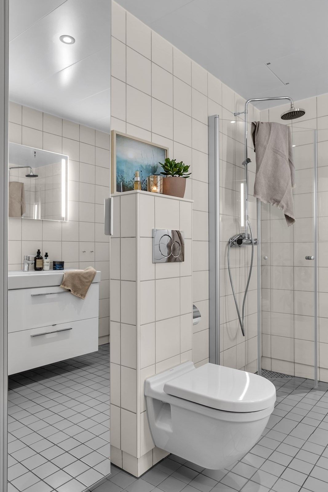 Badet er moderne og har vegghengt WC, innslagbare dusjdører, og praktiske innredninger