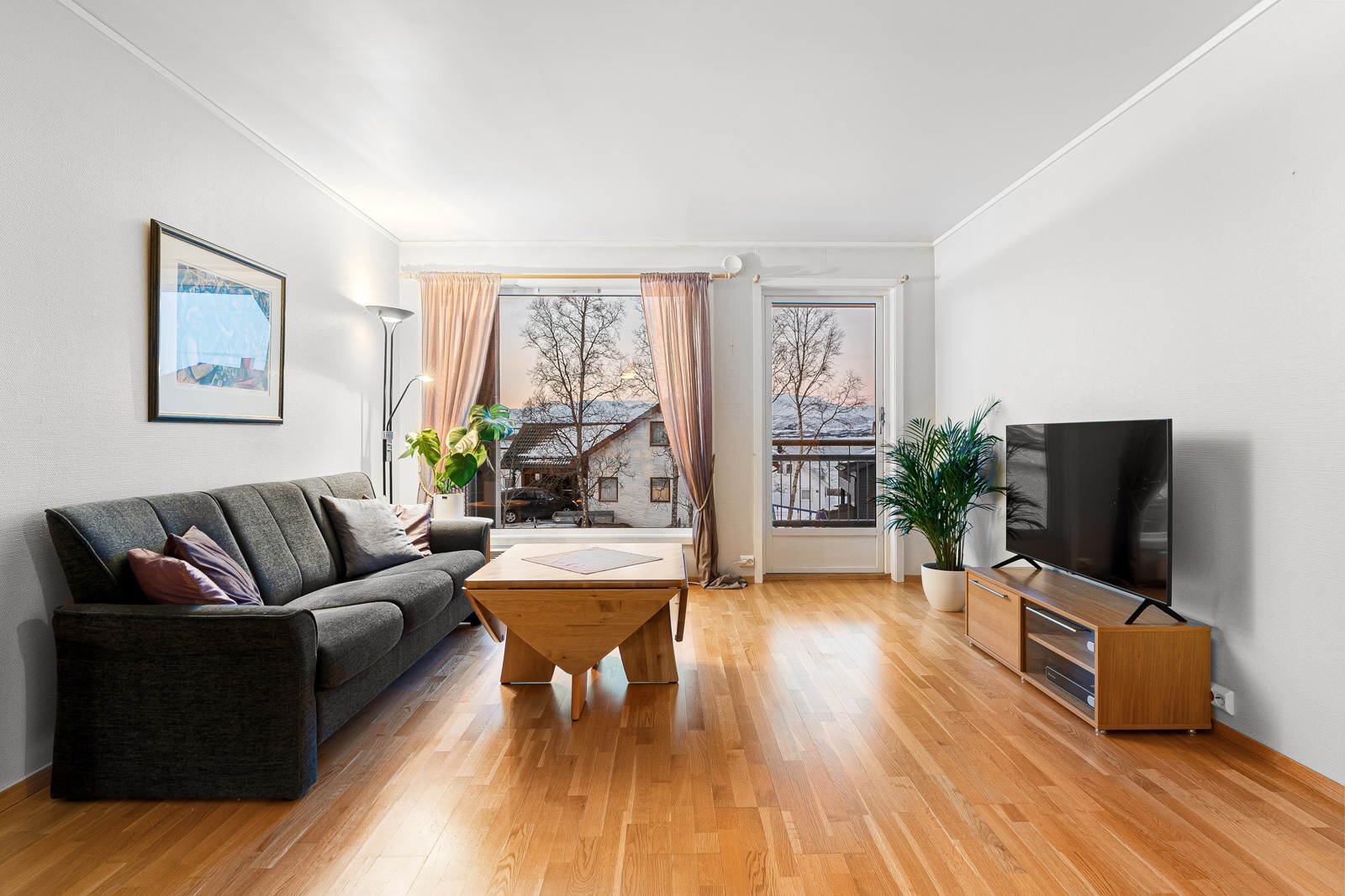 Leiligheten fremstår romslig med naturlige soner for både sofagruppen og spisebordet.