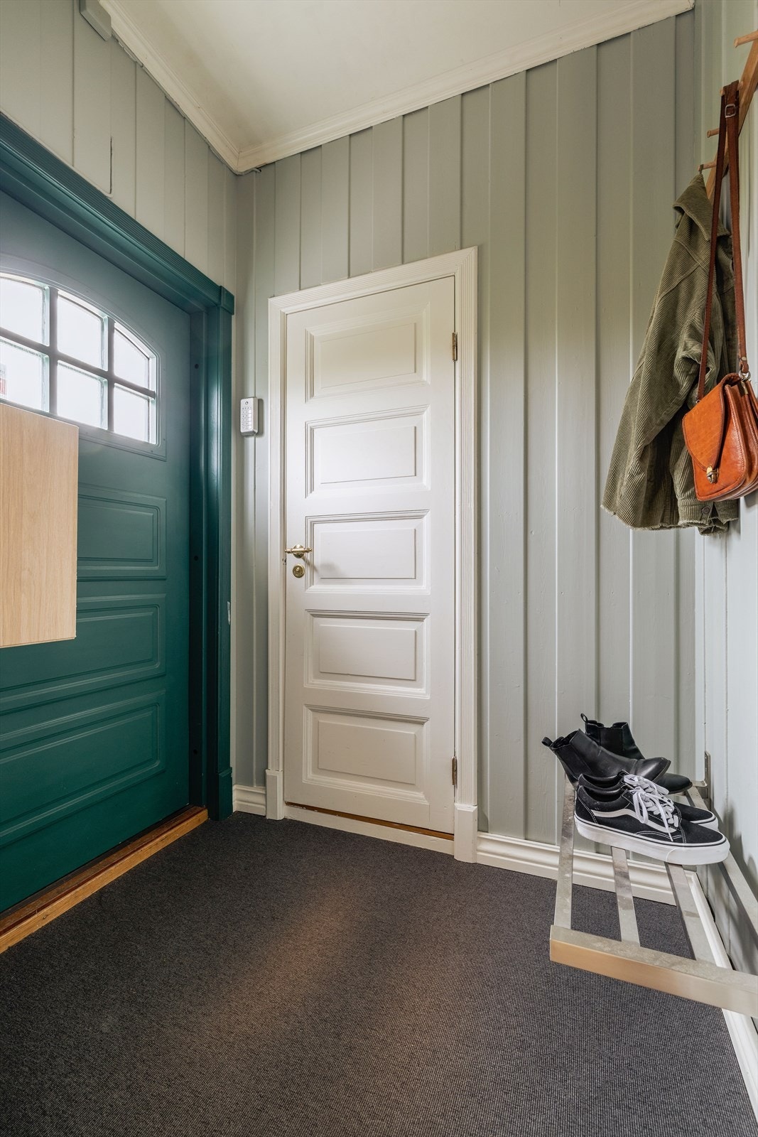 Pen entré på 2,3 m² med fin plass til å henge fra seg yttertøy og mulighet til å sette fra seg sko på veggmontert skohylle. Galleribilde