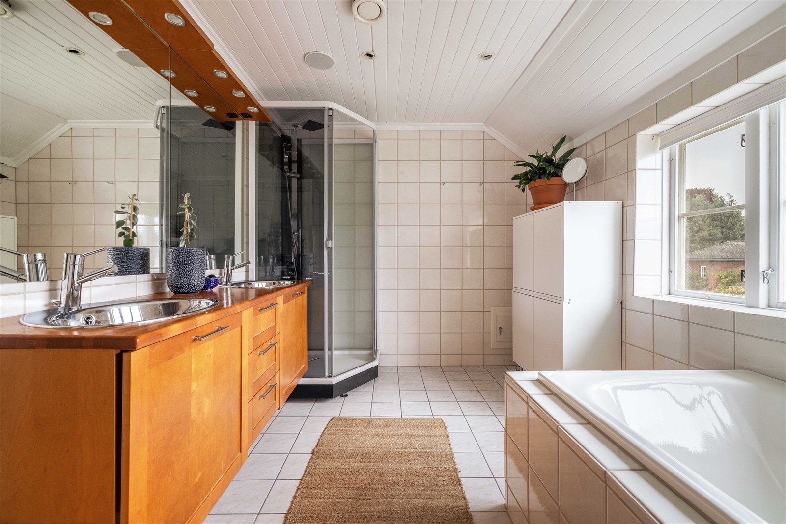 Lyst, flislagt baderom i 2. etasje, med standard fra 2010. Badet er 8,6 m² og er utstyrt med gulvvarme, dusjkabinett og innmurt badekar. Galleribilde