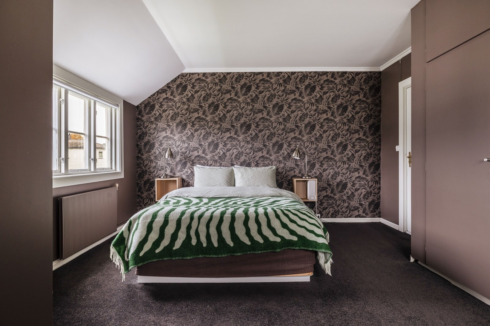 Hovedsoverommet fremstår lunt, med behagelig fargetoner og god plass til soveromsmøblement. Pen fondvegg med tapet. Galleribilde