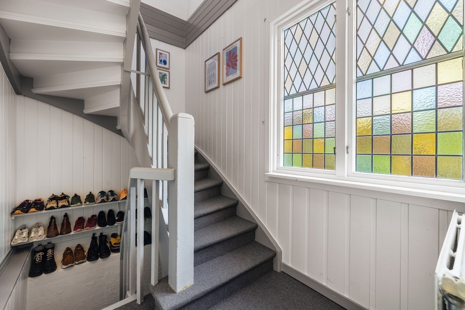 Trappegangen er på 5,4 m² og har oppgang til boligens 2. etasje via tett tretrapp fra byggeår, med teppe i trinn. Nedgang også til kjeller. Galleribilde