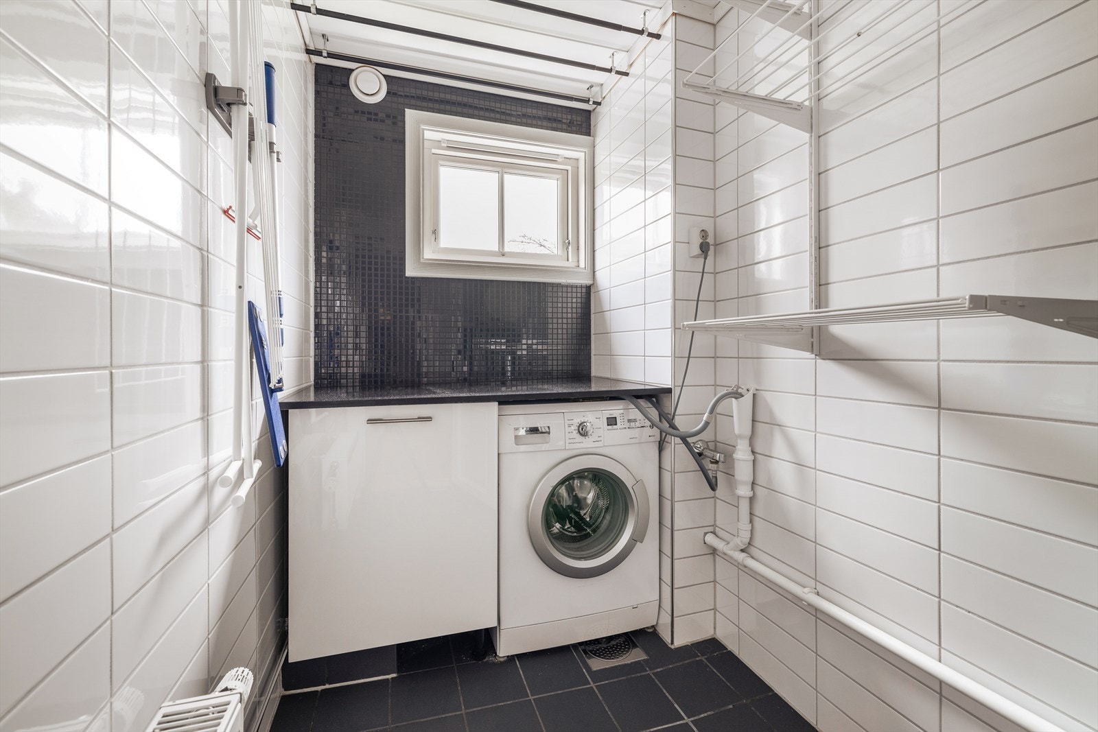 Eget, flislagt vaskerom fra 2010, praktisk tilliggende gang i 1. etasje. Vaskerommet har underskap med benkeplate i stein, opplegg for vaskemaskin og tørketrommel, samt skyllekar i stål. Galleribilde