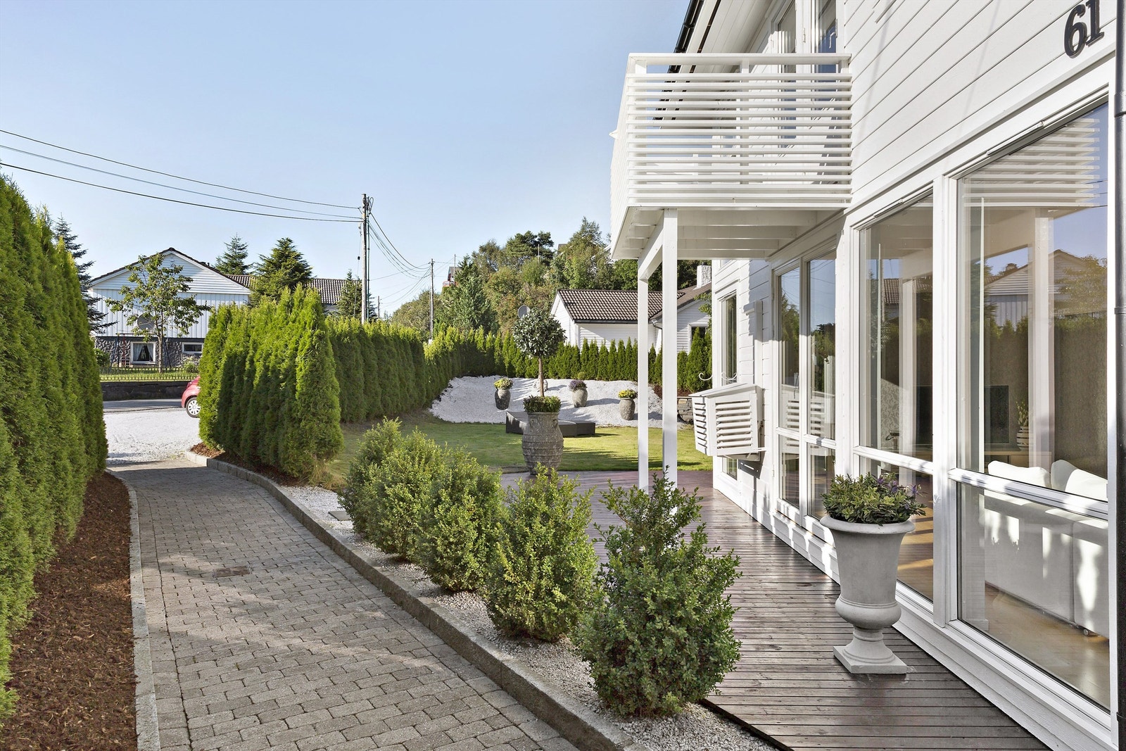 Usedvanlig pen opparbeidet tomt med belegningsstein, flotte natursteinsbed, terrasser og hage. Galleribilde