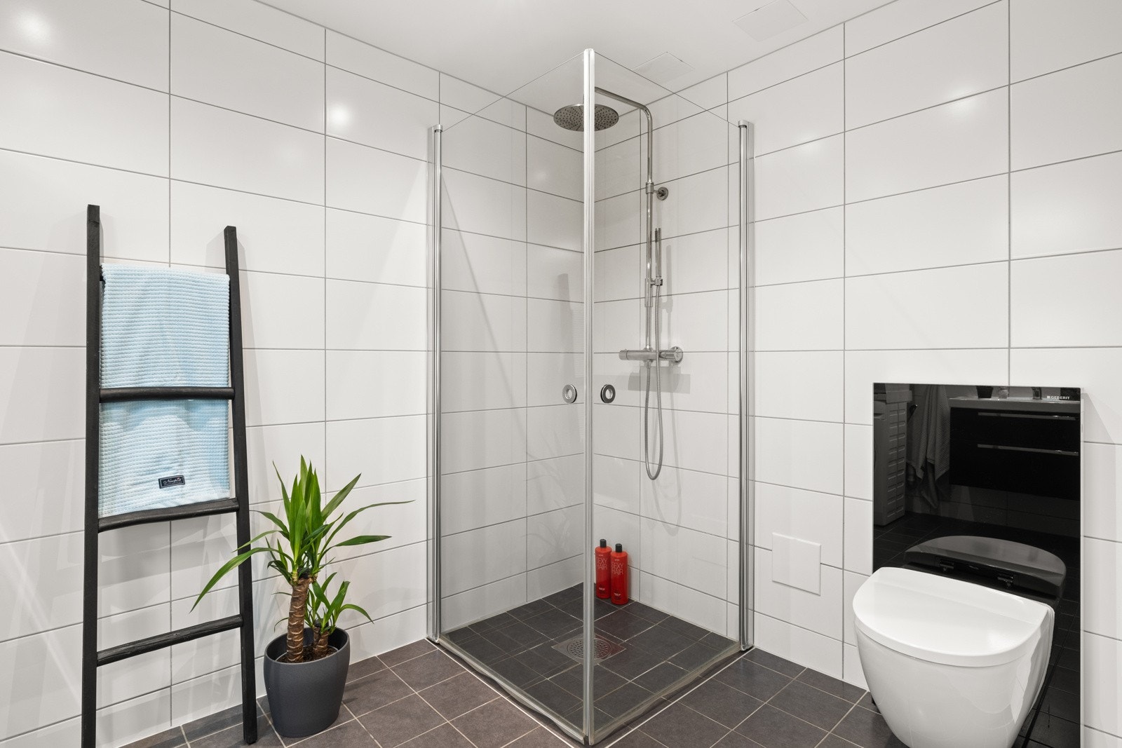 Badet har ellers vegghengt toalett, dusjhjørne med innfellbare dusjvegger og opplegg for vaskemaskin. Galleribilde