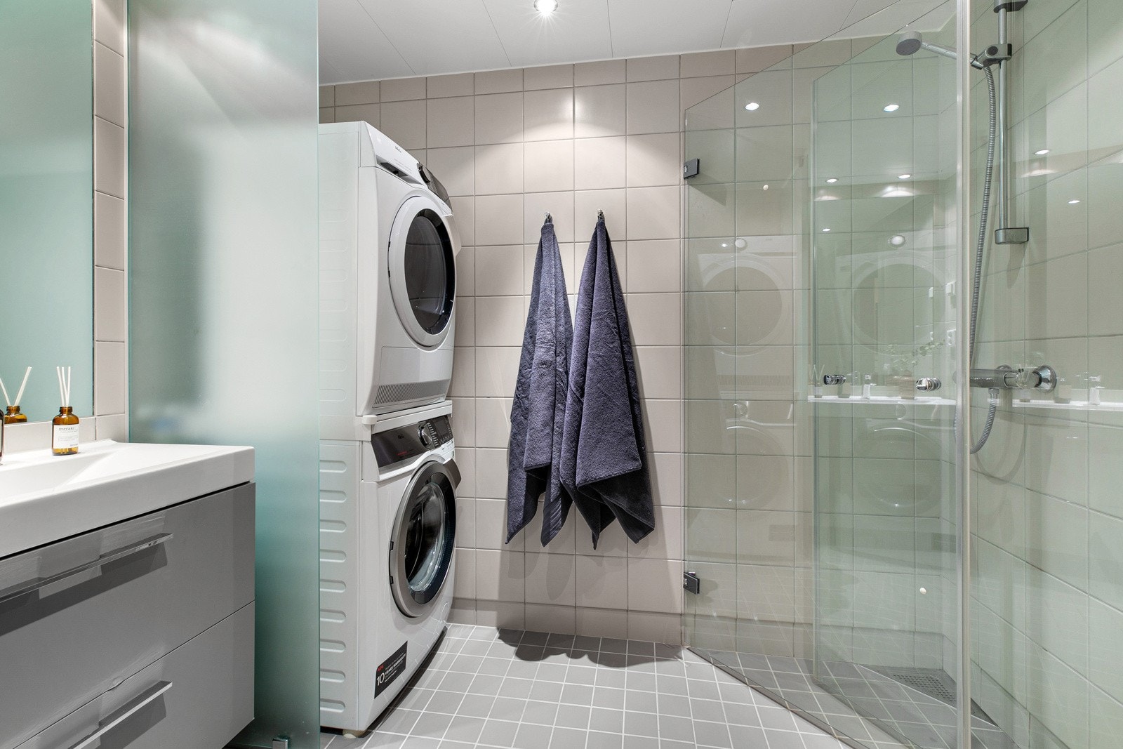 Tidløst flislagt bad fra byggeår med vannbåren gulvvarme og downlights i tak. Takhøyden på badet ble målt til ca. 2,24 m. Galleribilde