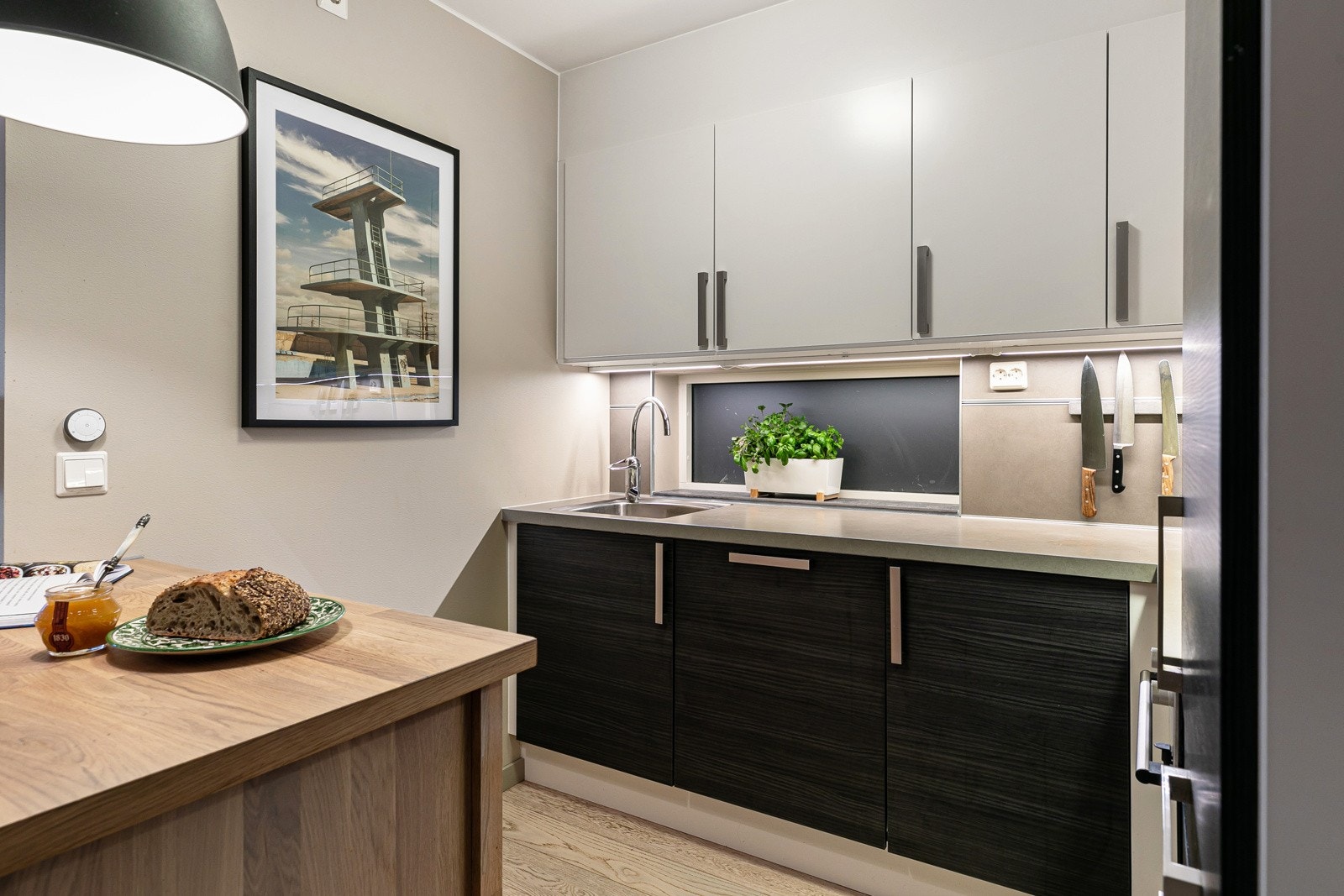 Innredningen er med sorte fronter på underskap og hvite overskap. Benkeplate i laminat, med nedfelt kum i rustfritt stål. Galleribilde