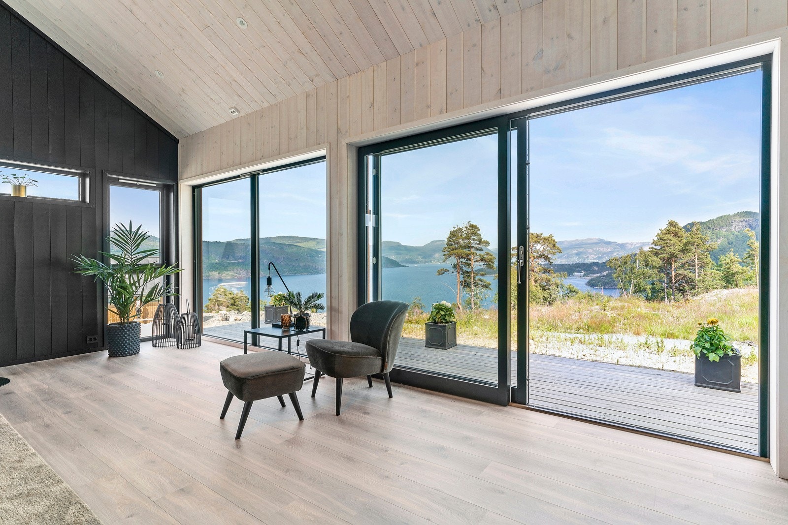 Stue med store vindusflater som slipper inn godt med dagslys Galleribilde