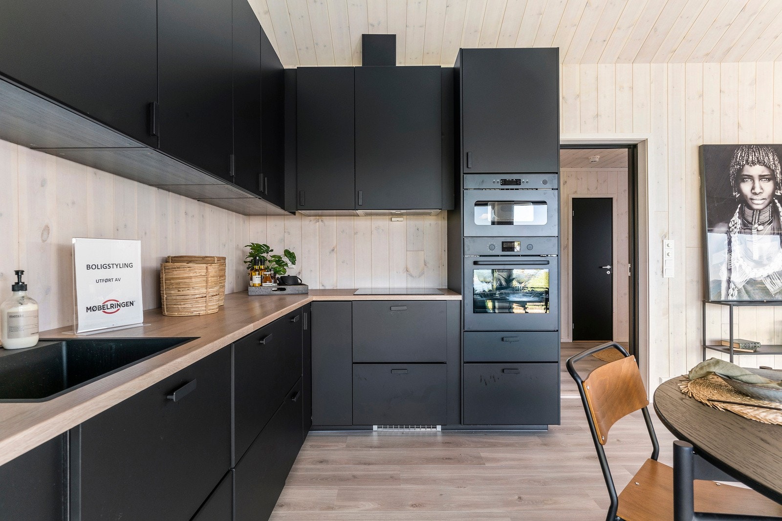 Stilfult kjøkken med slette sorte fronter og integrerte hvitevarer Galleribilde