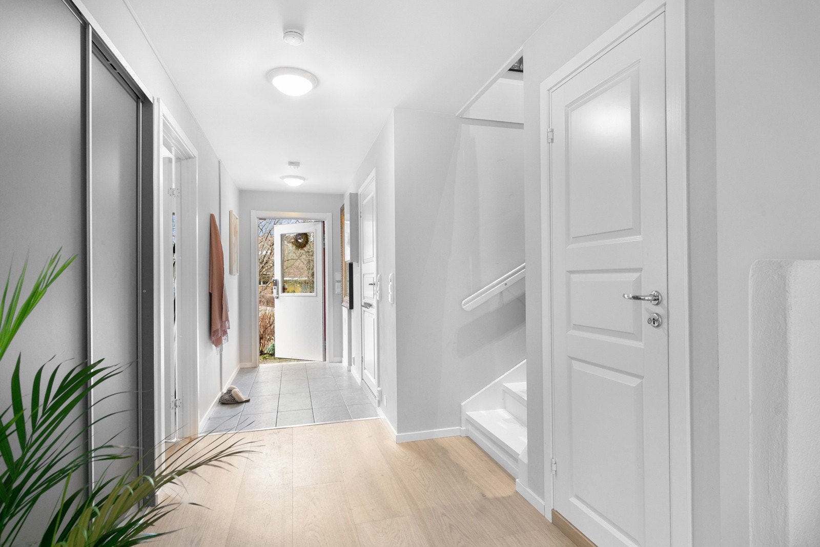 Entreen er romslig og innbydende, innredet med skyvedørsgarderobe. Det er varmekabler i det flislagte entréområdet Galleribilde
