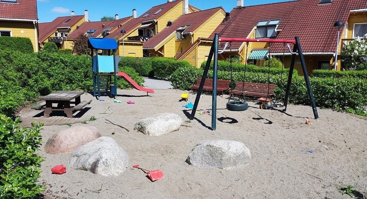 Blandt husene er det sandkasser og lekestativ for de minste Galleribilde