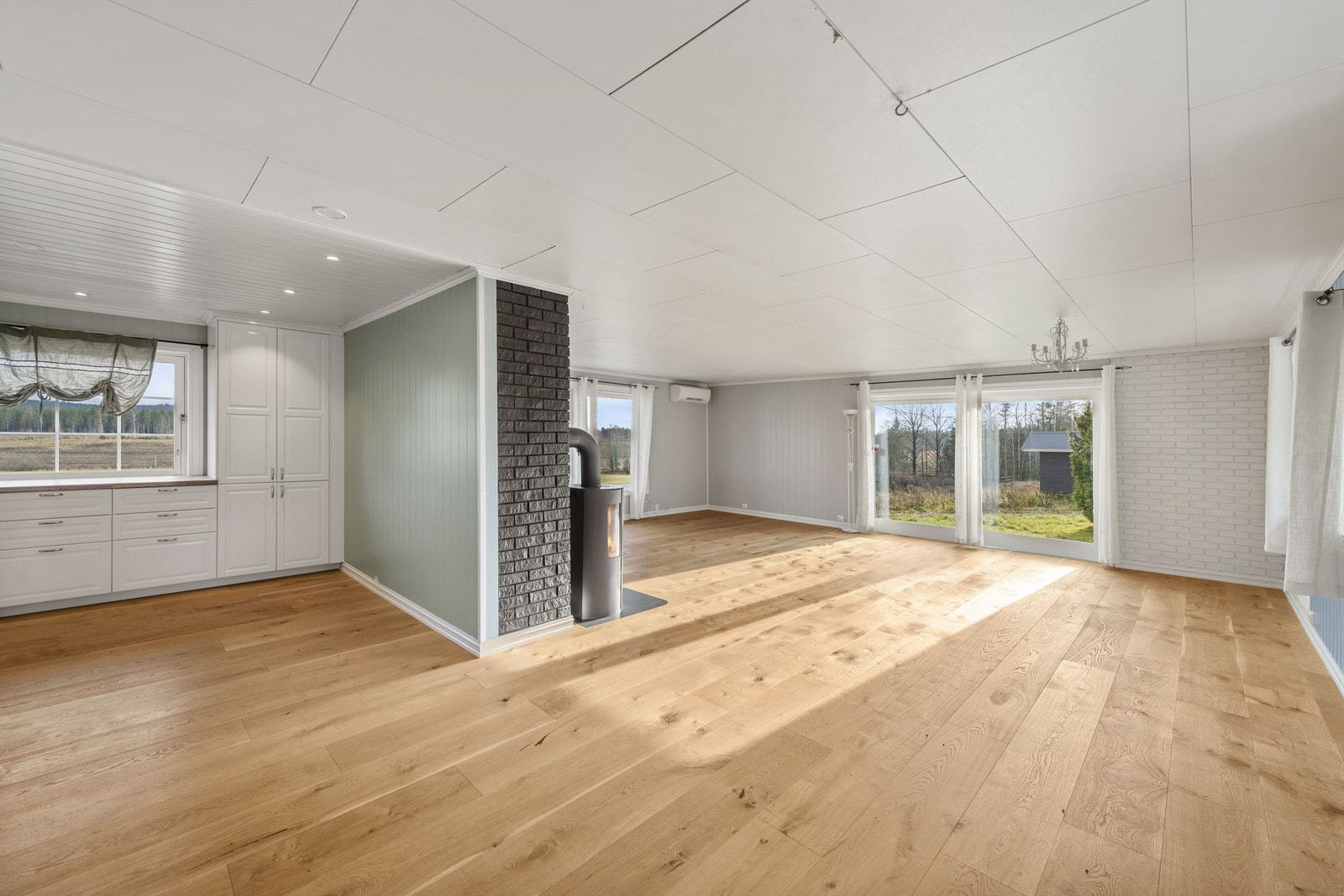 Den romslige stuen i boligens første etasje byr på god plass og suppleres fint av en tradisjonell vedovn. Galleribilde