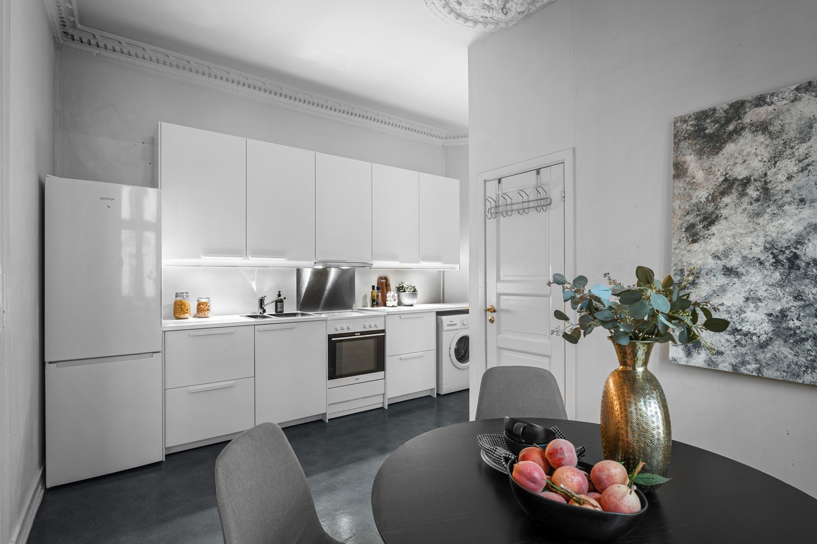 Spisekjøkken med glatte, hvite fronter og god takhøyde. Galleribilde