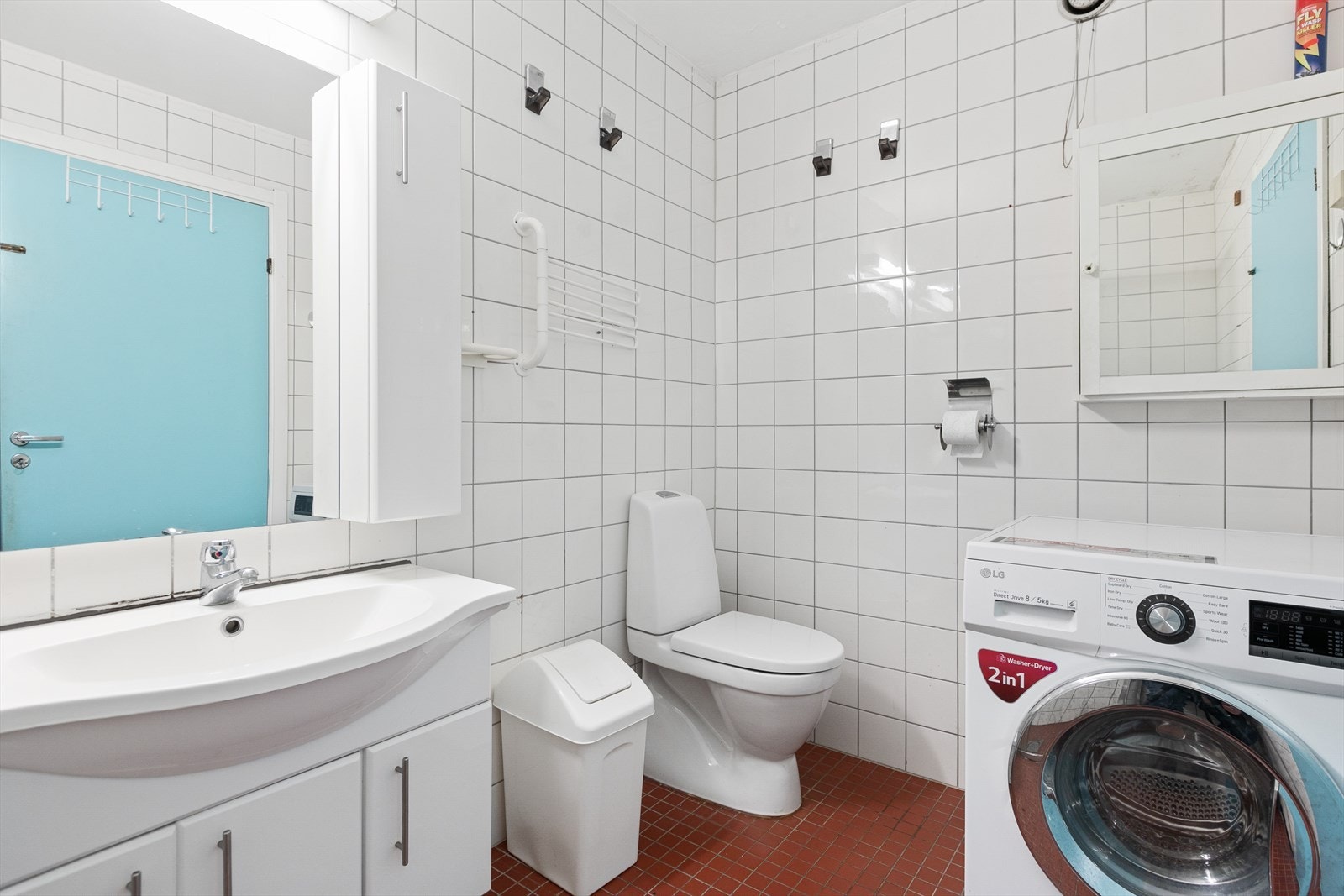 Badet består av servant med skap, toalett, dusj og opplegg til vaskemaskin Galleribilde