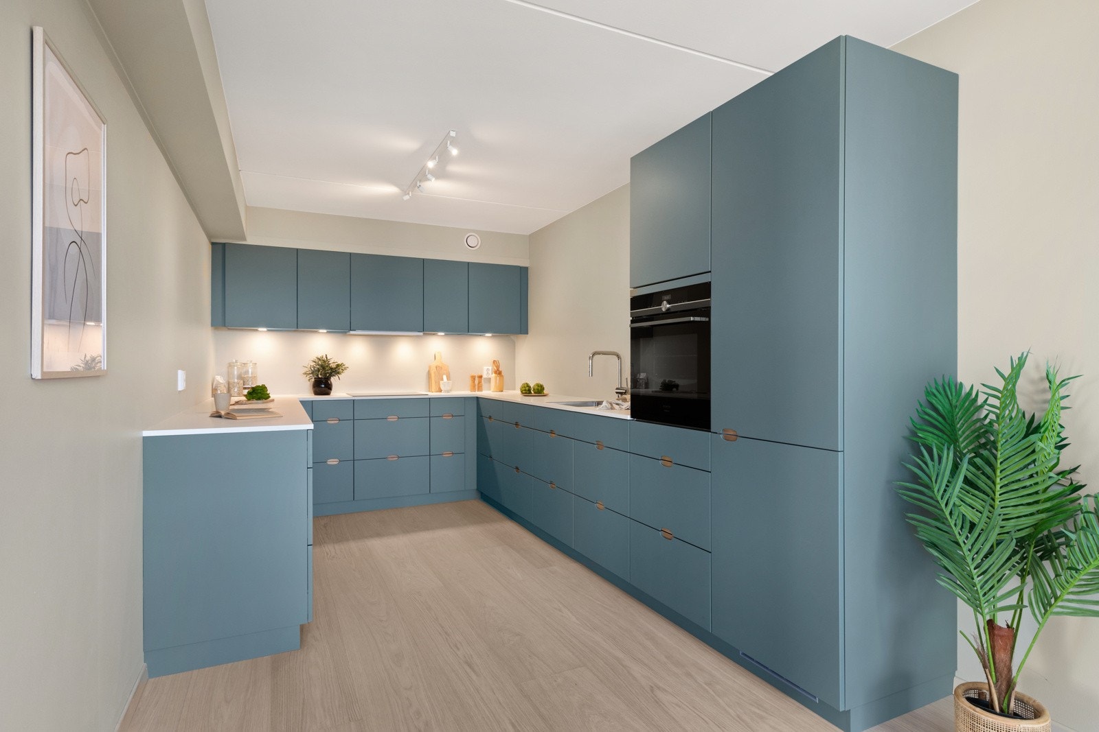 Innredningen har slette fronter i en delikat farge, benkeplate i laminat med underlimt kum og blandebatteri med uttrekksfunksjon. Galleribilde