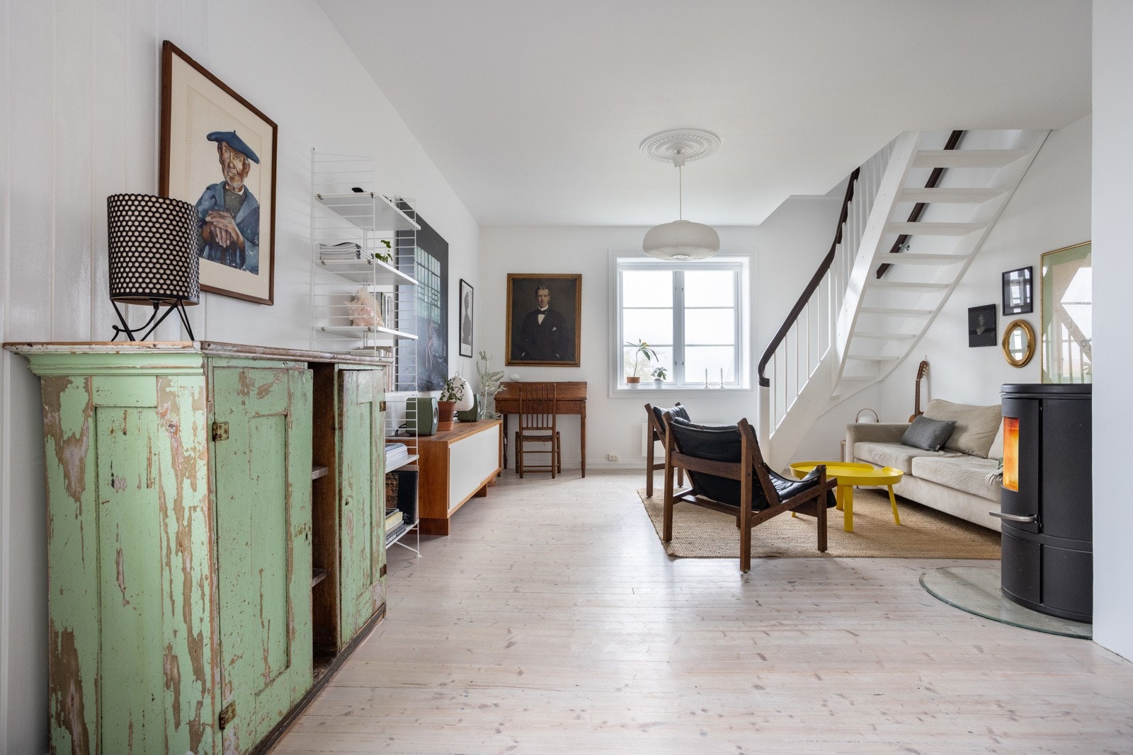 Innvendig blir man møtt av lyse, delikate overflater, og sjarmerende detaljer med originale tregulv og flott peisovn. Galleribilde