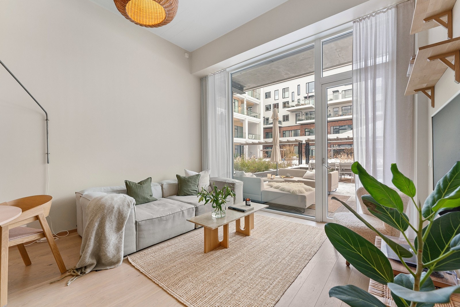 I stuen har man store vindusflater mot uteplass og bakgård. Dette bidrar med mye naturlig lys inn i stuen og kjøkkenet Galleribilde