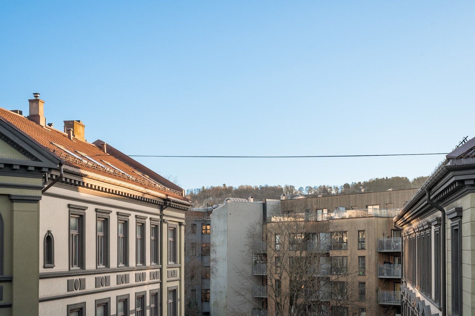 Fritt utsyn mot felles bakgård fra kjøkken. I bakgrunnen kan toppen av Ekeberg skimtes. Galleribilde