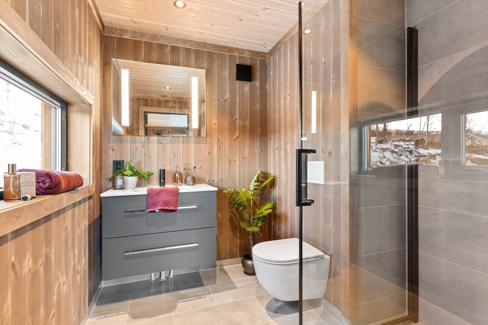 Sanitærutstyr bestående av baderomsinnredninger med speil over, dusjnisje og vegghengt toalett Galleribilde