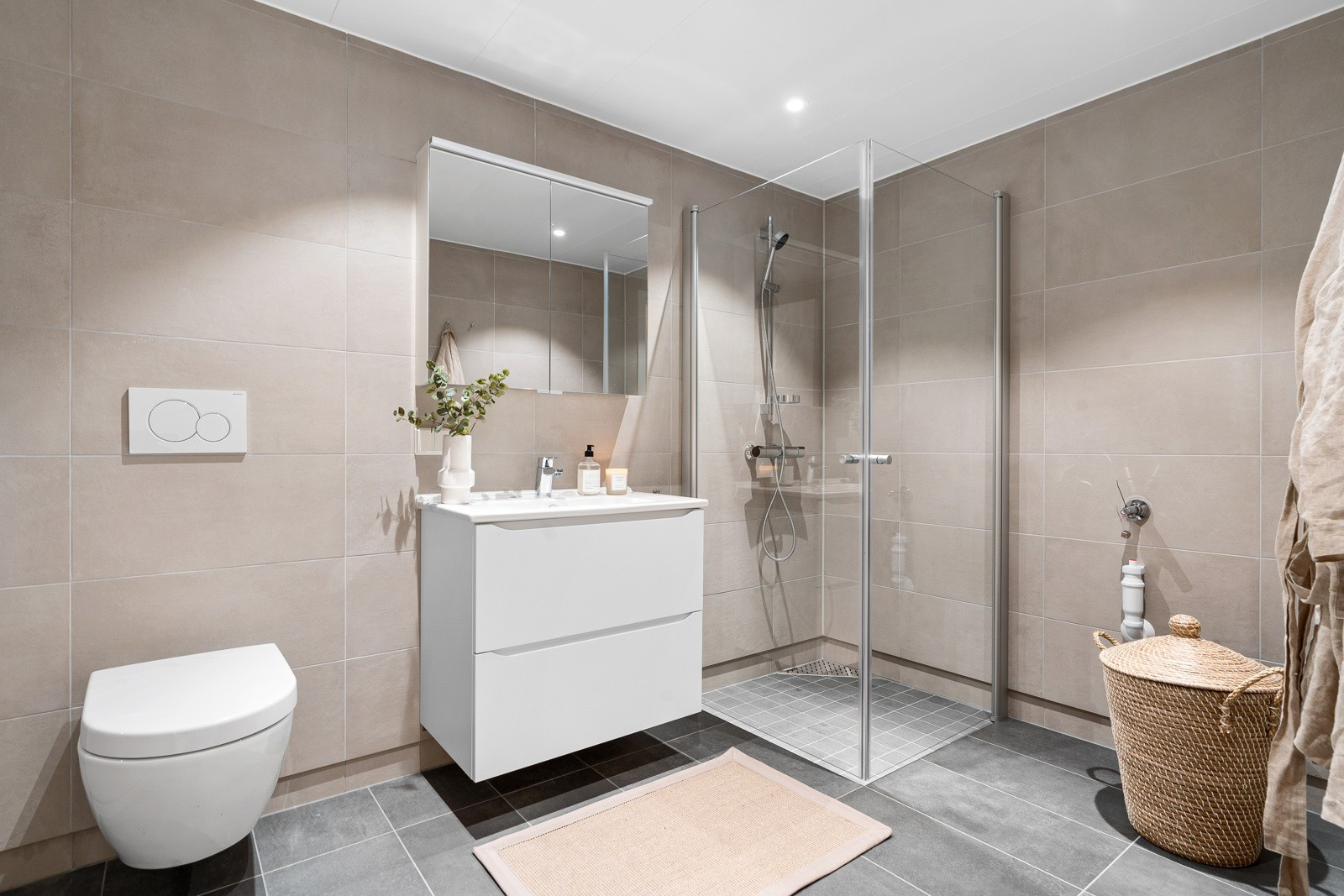 Badet fremstår delikat med oppgraderte fliser. Her har du stort dusjhjørne og godt med plass for vaskemaskin/tørketrommel.