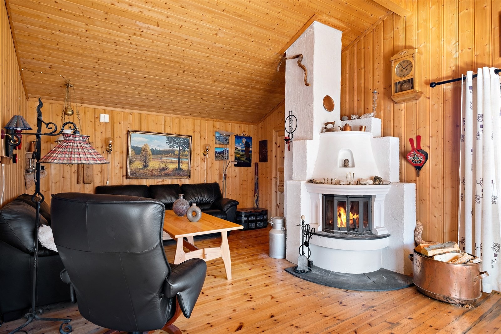 Peisen er smykket i stova. Stova kan fint delast inn i fleire soner. Galleribilde