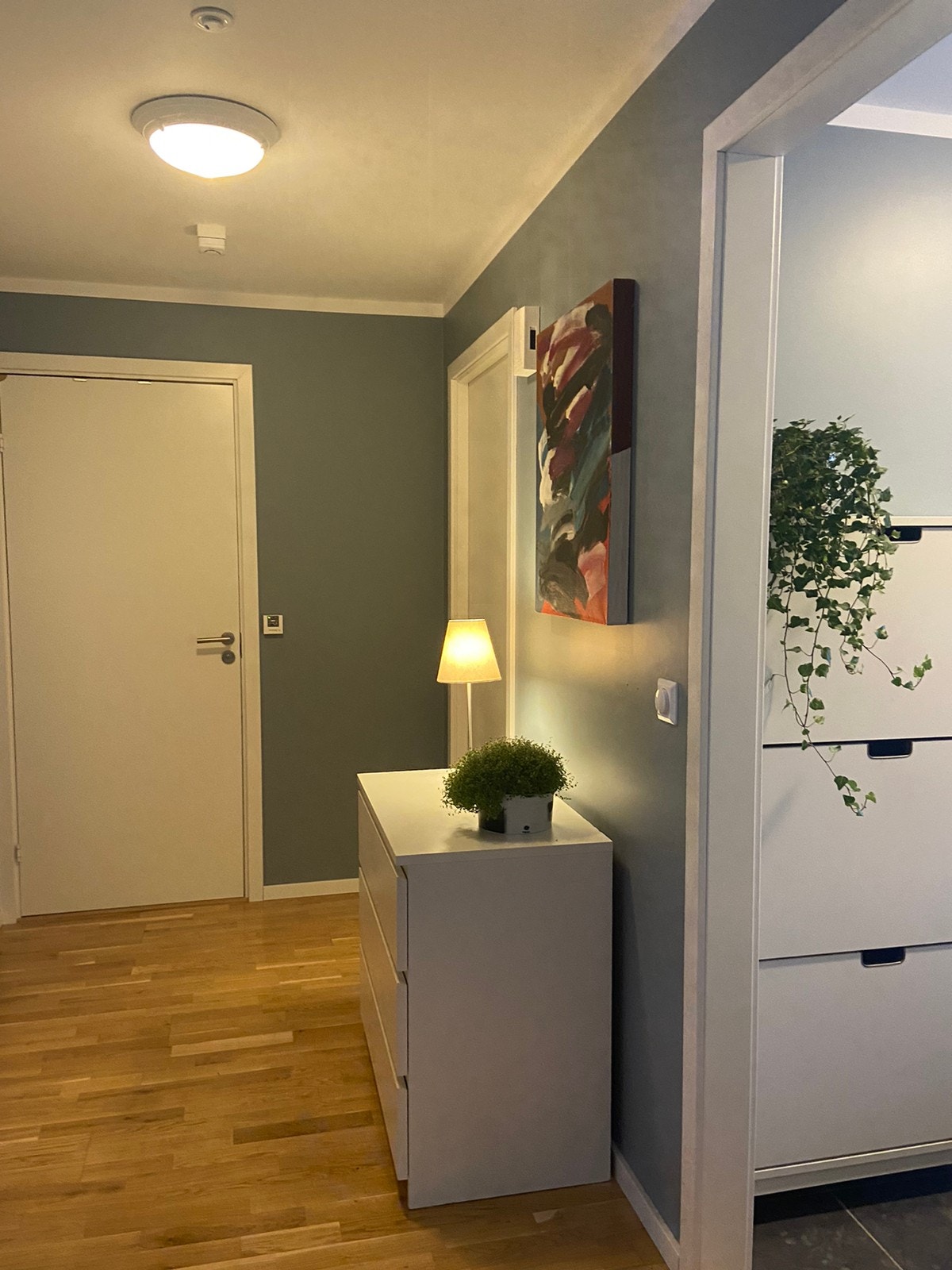 Gang med dør til baderom, lite soverom og yttergang med skyvedørsgarderobe og vannbåren varme i flisegulv Galleribilde