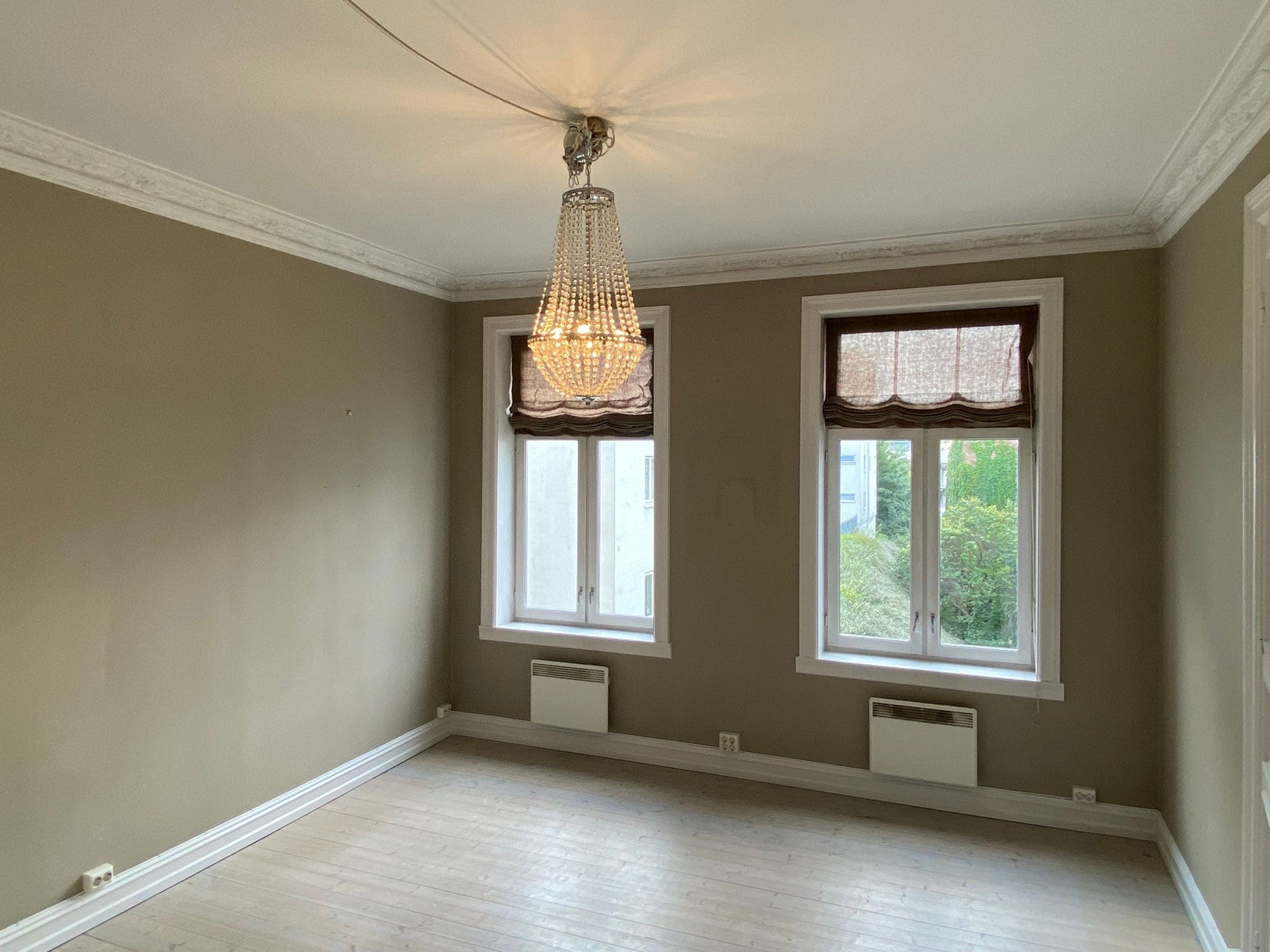 Generøs takhøyde og originale tregulv i stue/sov. Galleribilde