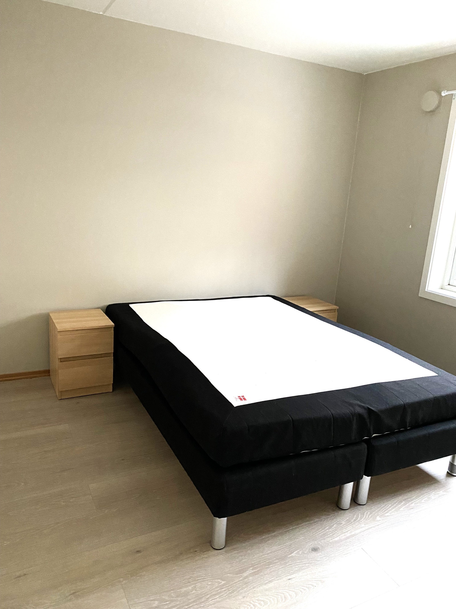Romslig soverom med stor seng og nattbord Galleribilde