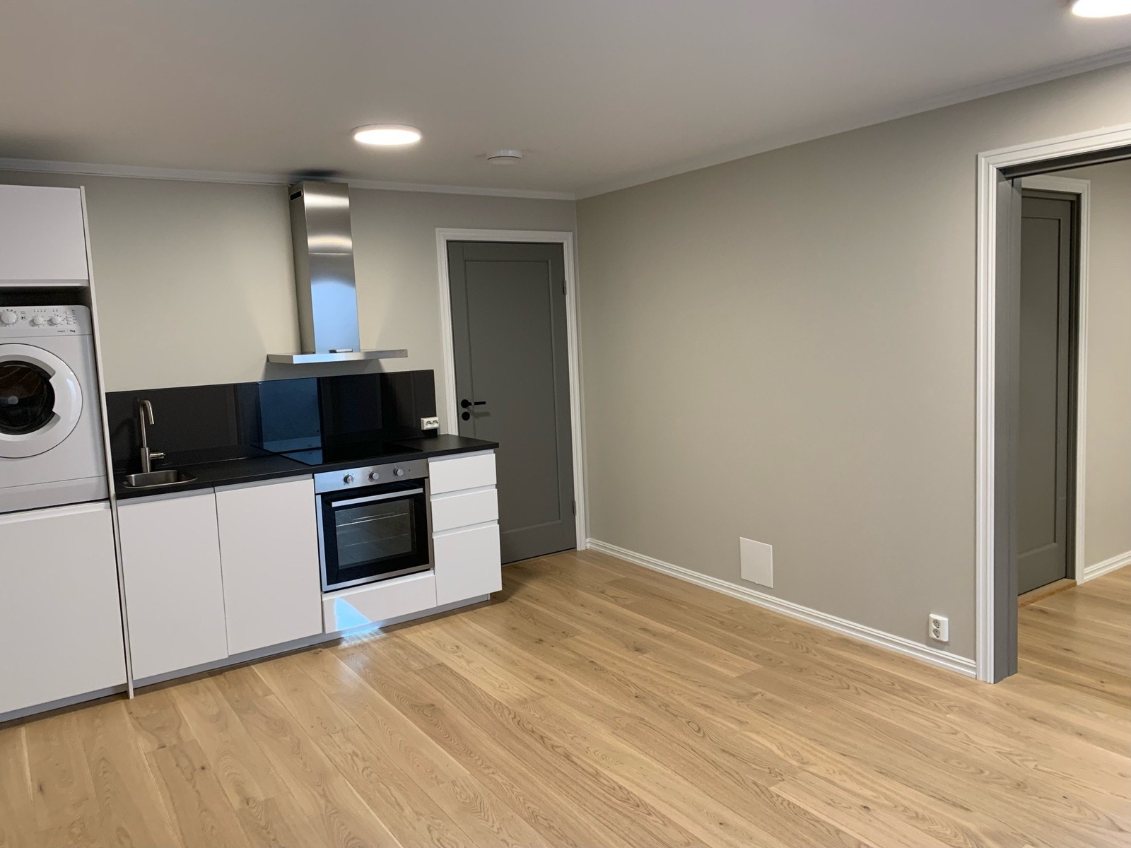 Kjøkken med vaskemaskin, oppvaskmaskin, komfyr og koketopp Galleribilde