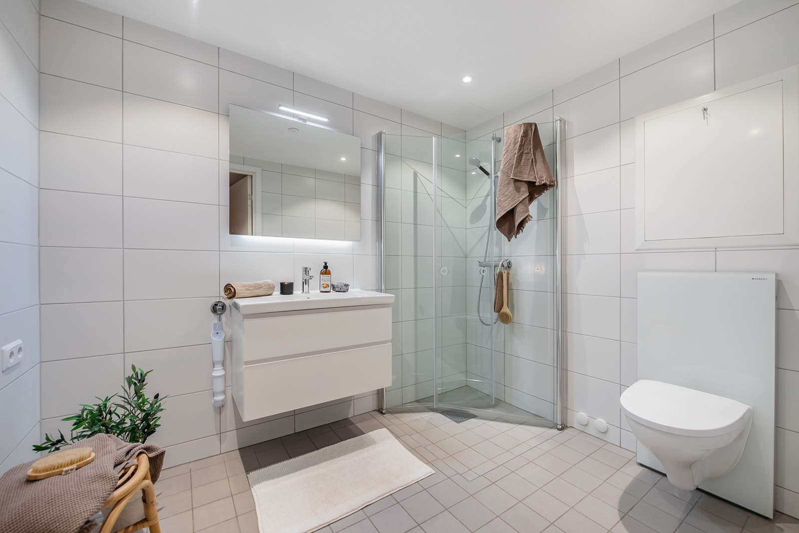 Delikat bad i lyse farger, flislagte vegger og gulv. Galleribilde