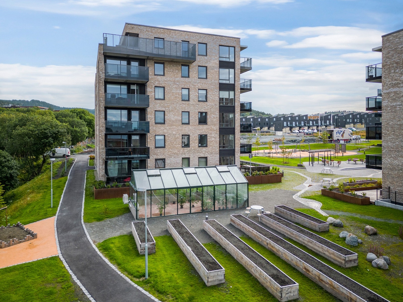 Stort drivhus til felles benyttelse for beboerne, hvor man kan dyrke tomater og annet. Flere dyrkekasser er også plassert på fellesområdene. Galleribilde