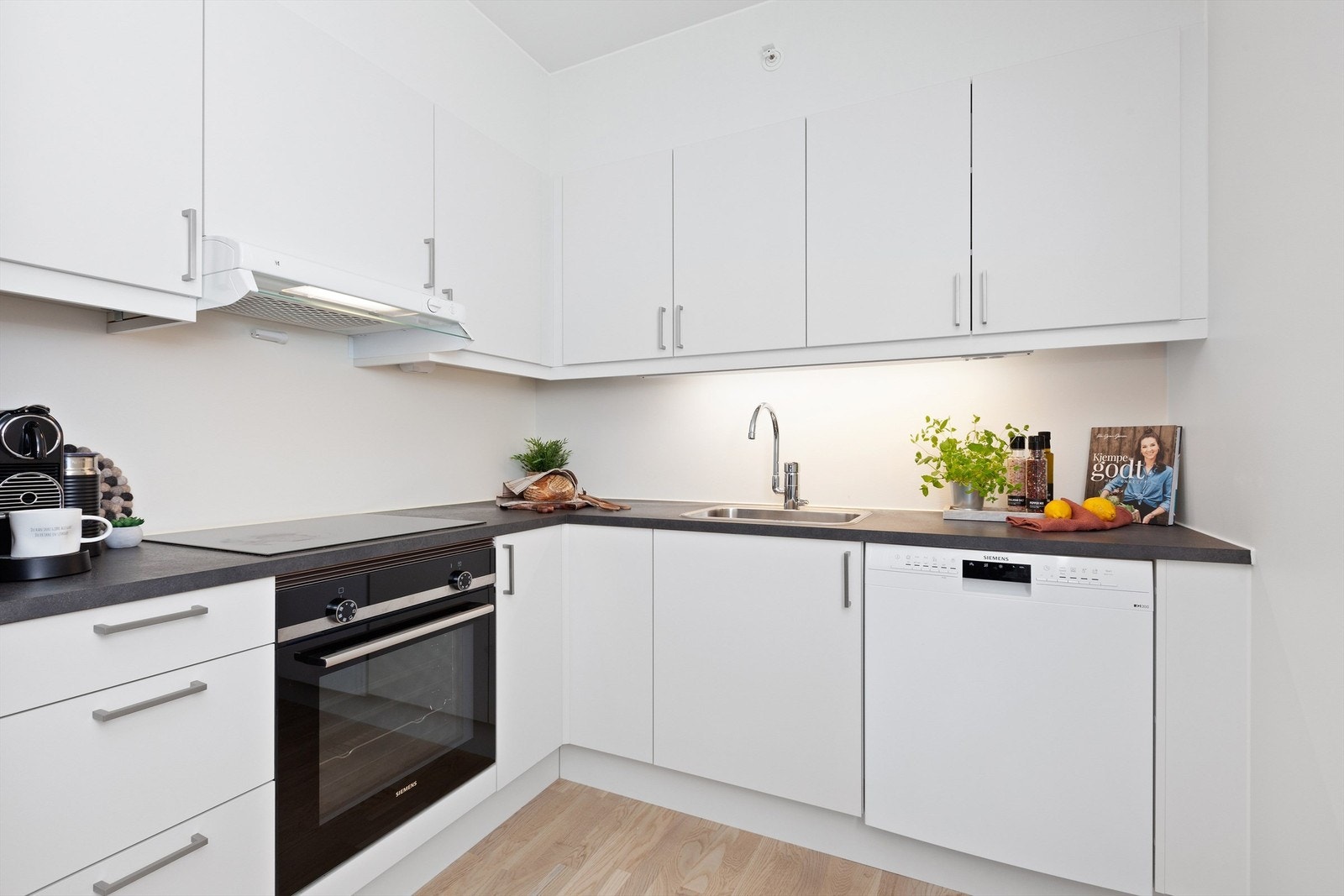 Flott kjøkkeninnredning med hvite glatte skapfronter og laminat benkeplater Galleribilde