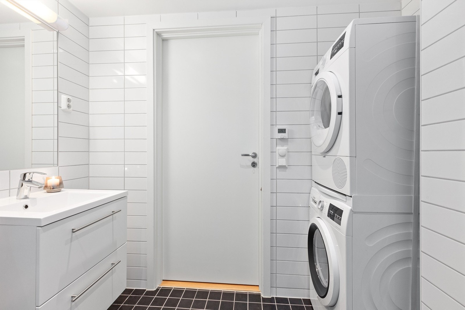 Badet består av dusj på gulv med dusjdører i herdet glass, servant med skuffeinnredning, klosett med vegghengt klosettskål og innebygget sisterne Galleribilde