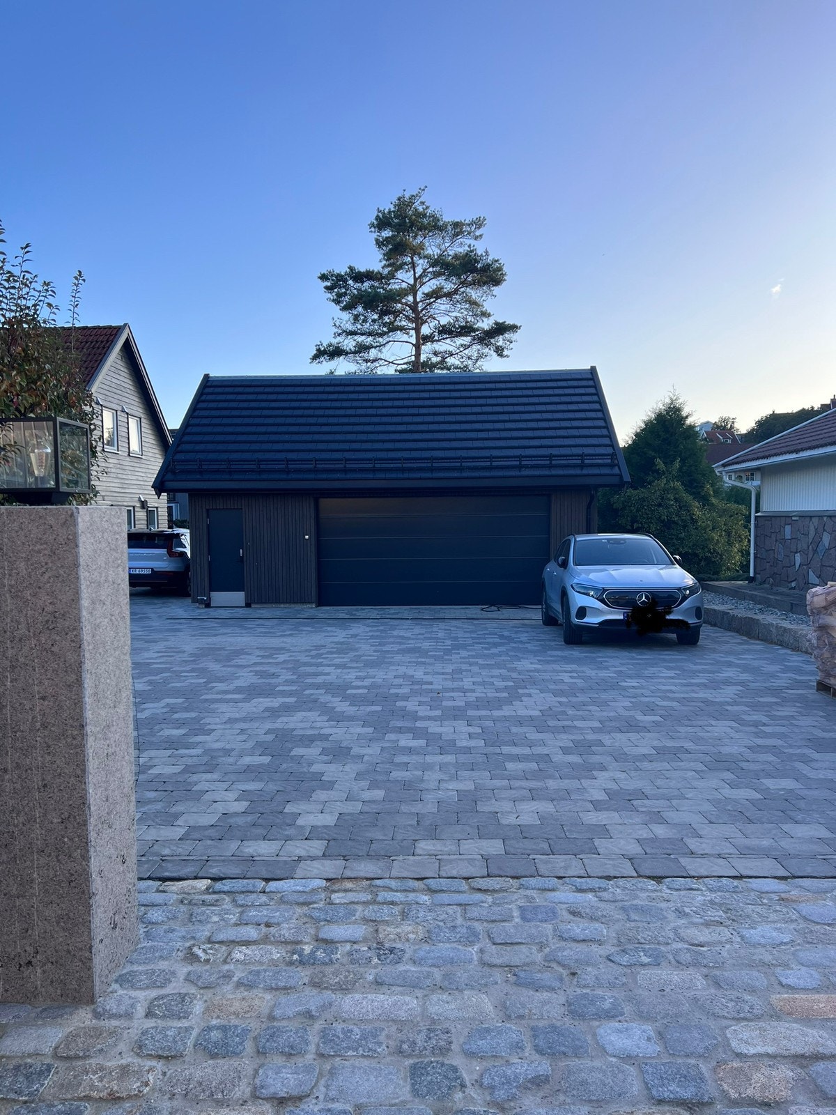 Parkeringsplass foran garasjen der hvor den sølvgrå bilen står. Galleribilde