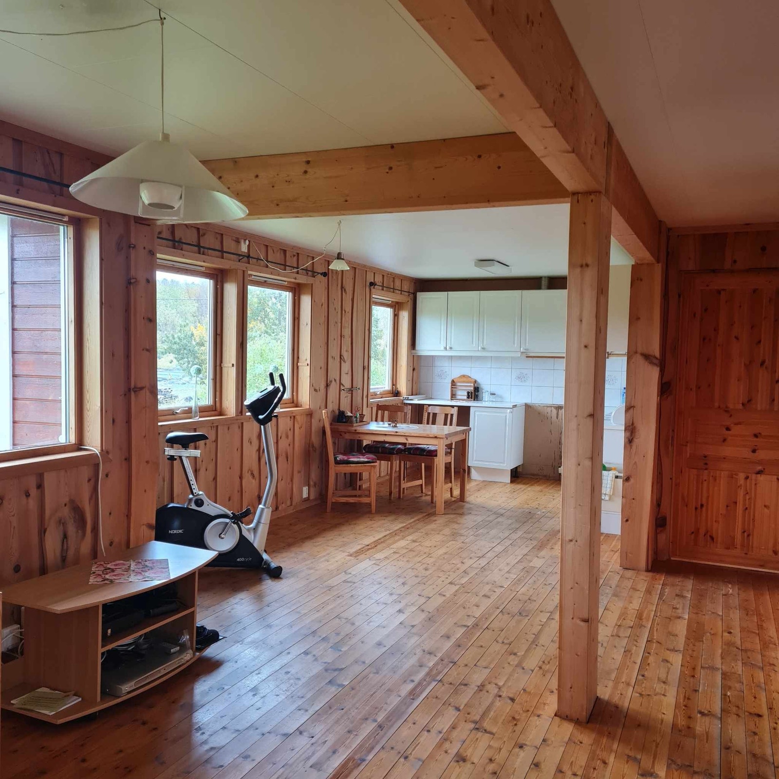 Kjøkken og stue er kledd med Villmarks-panel. Gulvene i etasjen er i parkett.
Bilde tatt mot kjøkkenet. Dør til entreen. Galleribilde