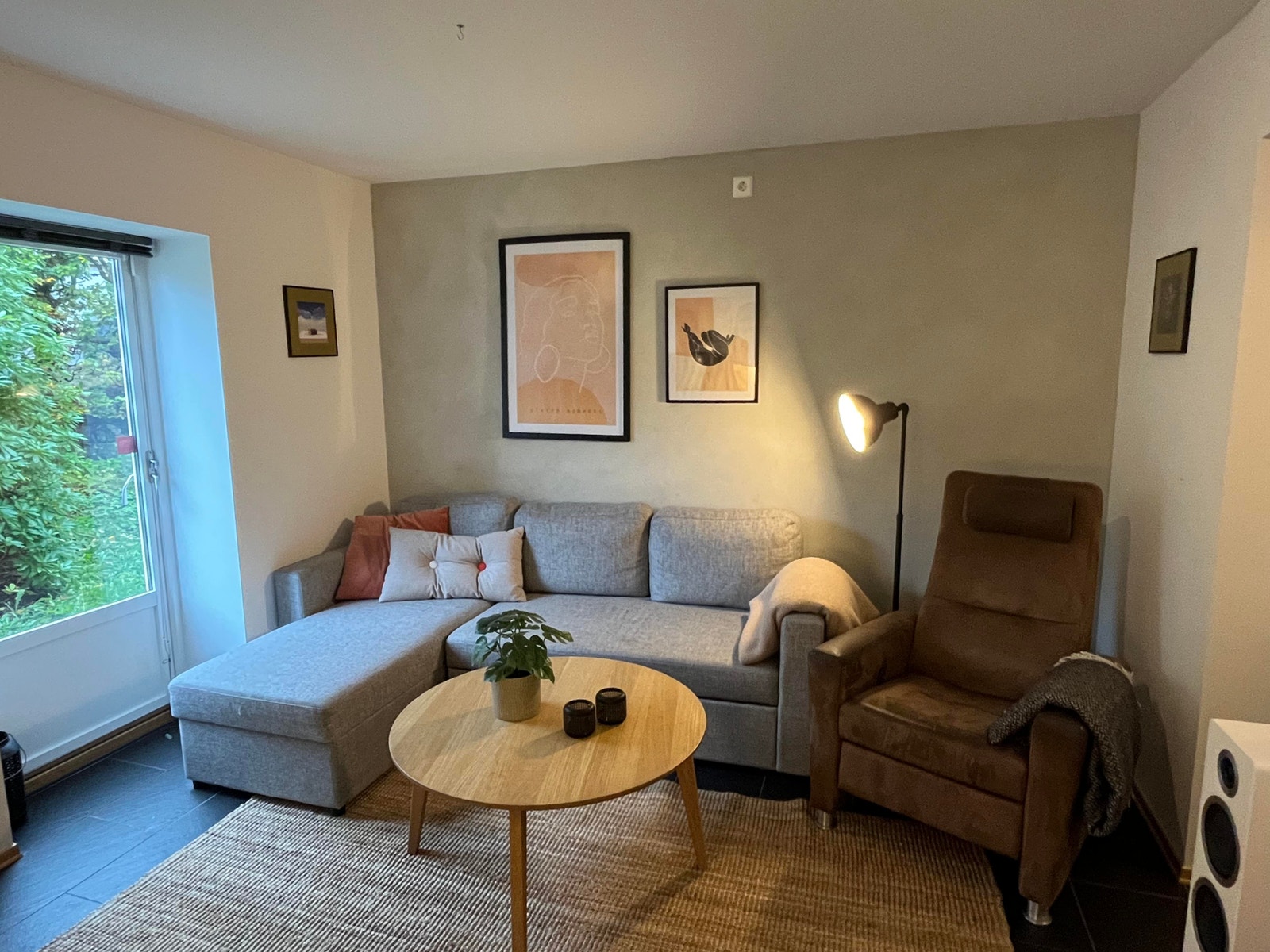 Fin stue med sovesofa og stor lenestol, med tv rett ovenfor. Glassdør til venstre gir masse lys, og åpner rommet. Galleribilde