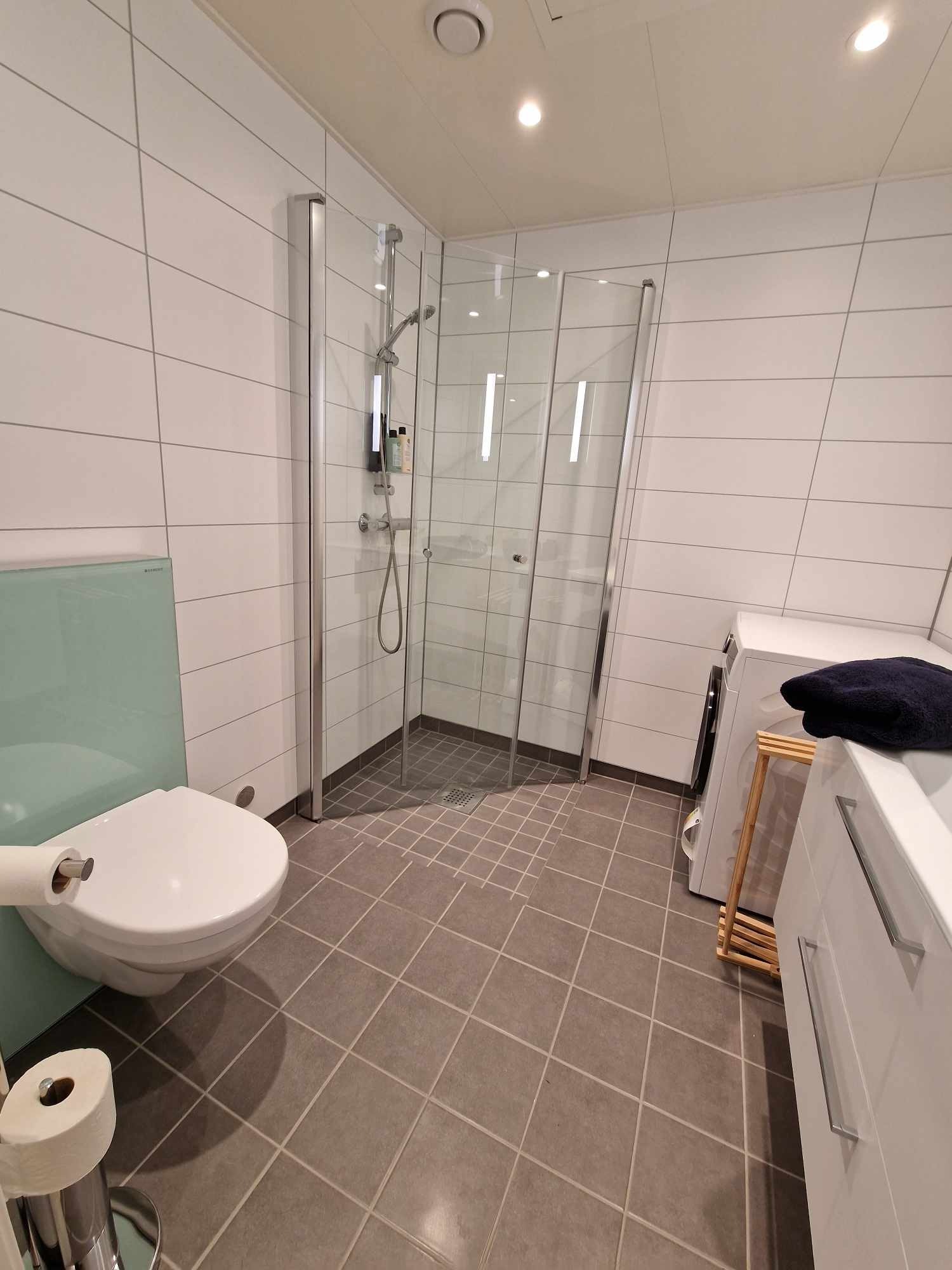 Bad med dusjvegger en kan legge inn til veggen for bedre plass Galleribilde