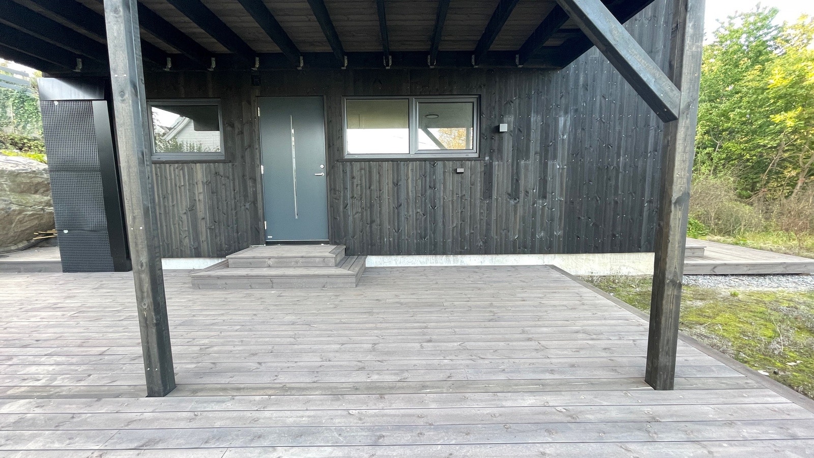 Hovedinngang med stor terrasse under tak Galleribilde