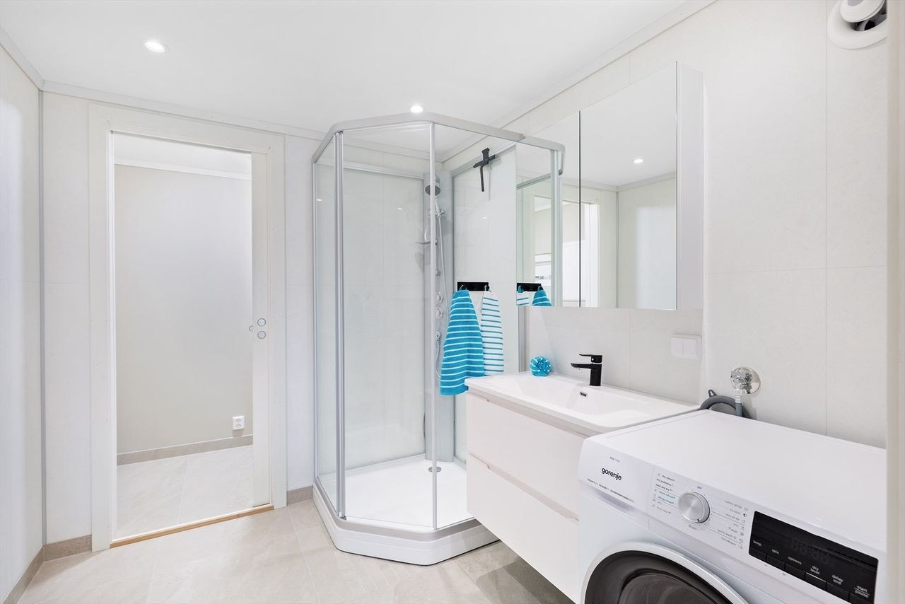 Badet er nytt, innredet med servant-skap med to skuffer, speilskap over vask, vegghengt toalett og dusjkabinett. Galleribilde