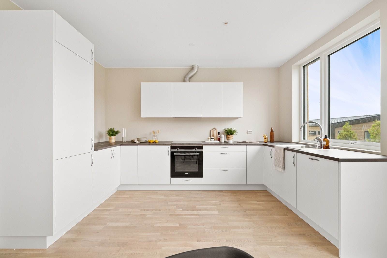 Kjøkkenet er utstyrt med integrerte hvitevarer bestående av platetopp, stekeovn, oppvaskmaskin og en kombinert kjøl/frys. Galleribilde