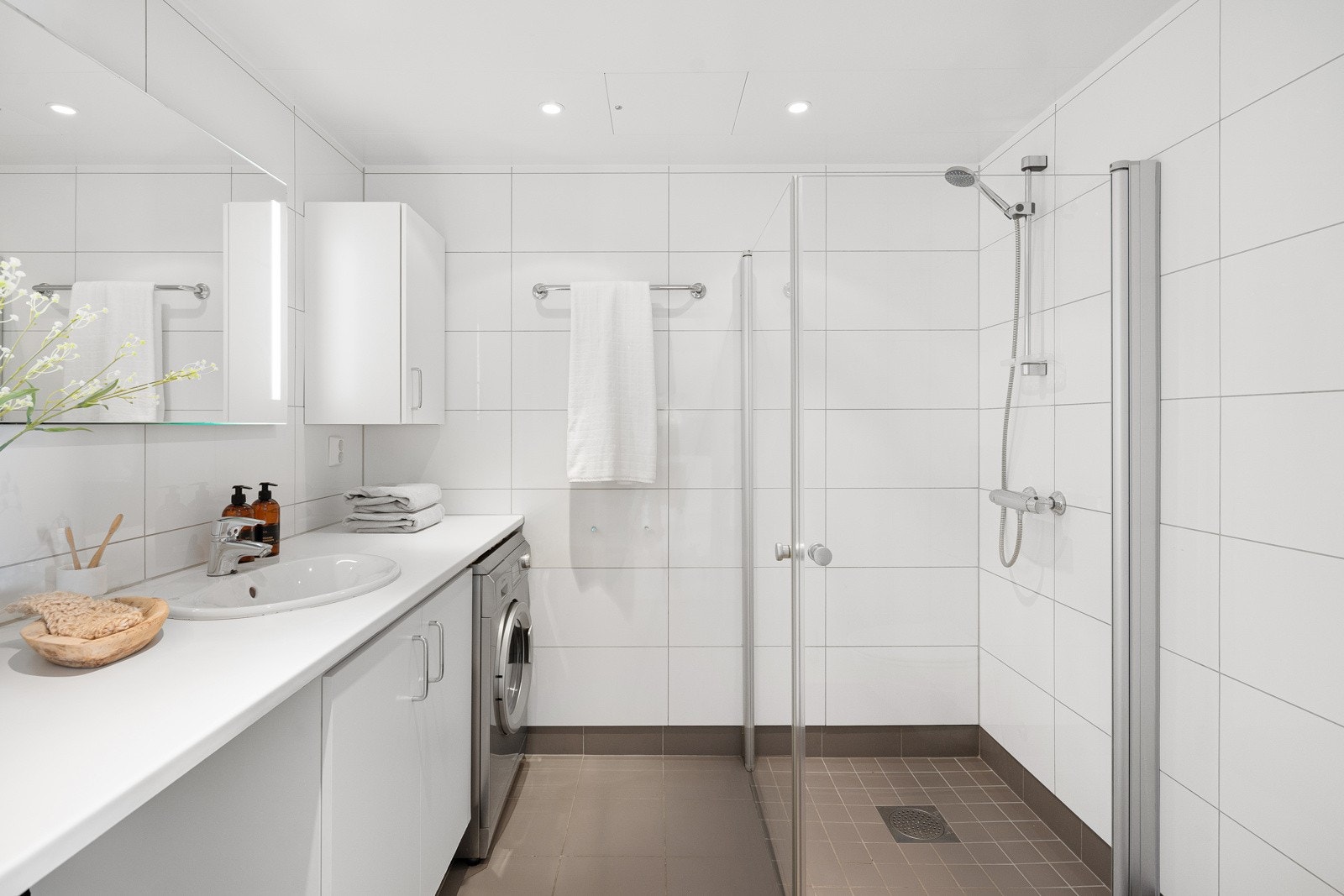 Stort baderom med lyse flis- og materialvalg. Galleribilde