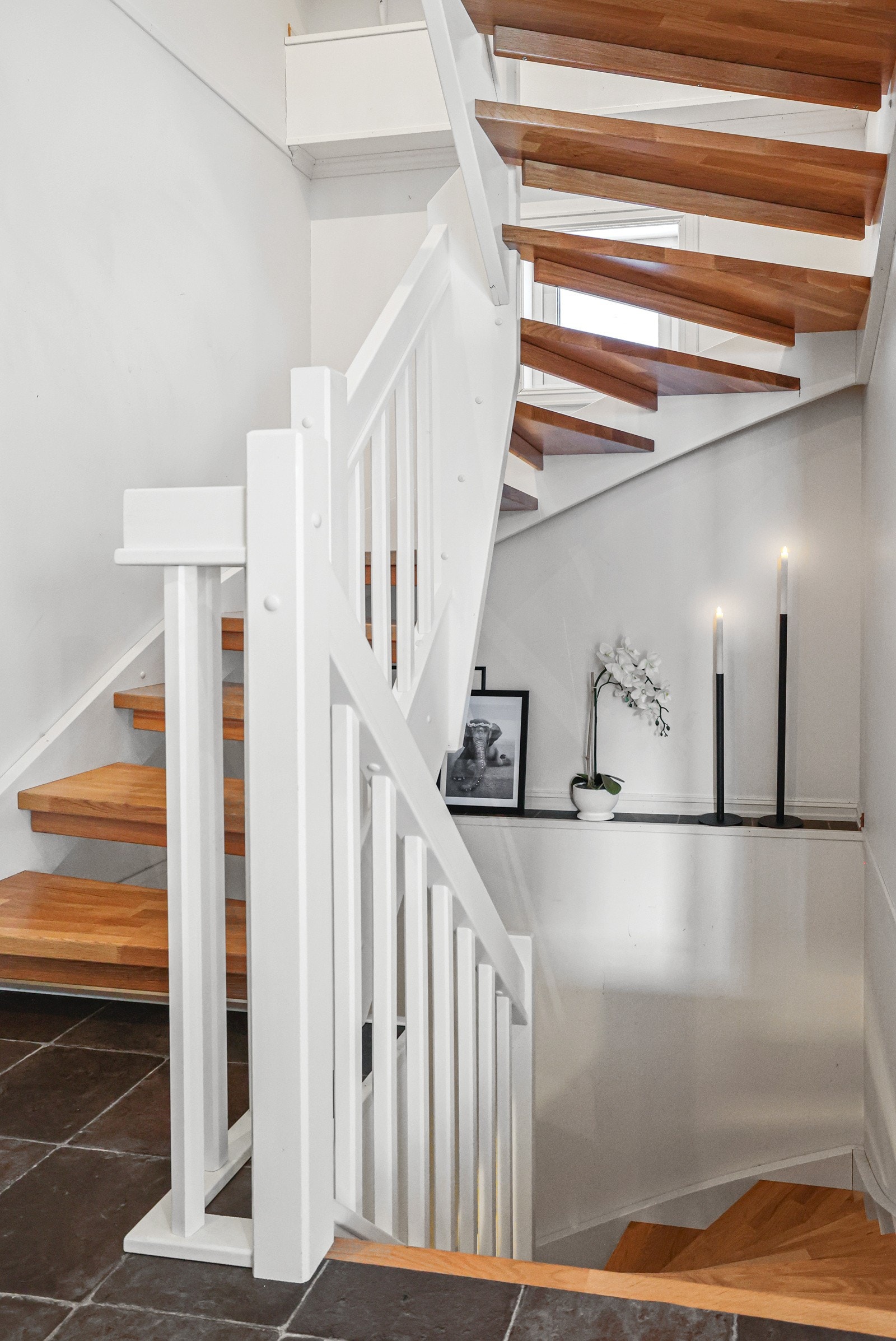 Huset har en hvit svingtrapp som fører deg til alle etasjene. Galleribilde