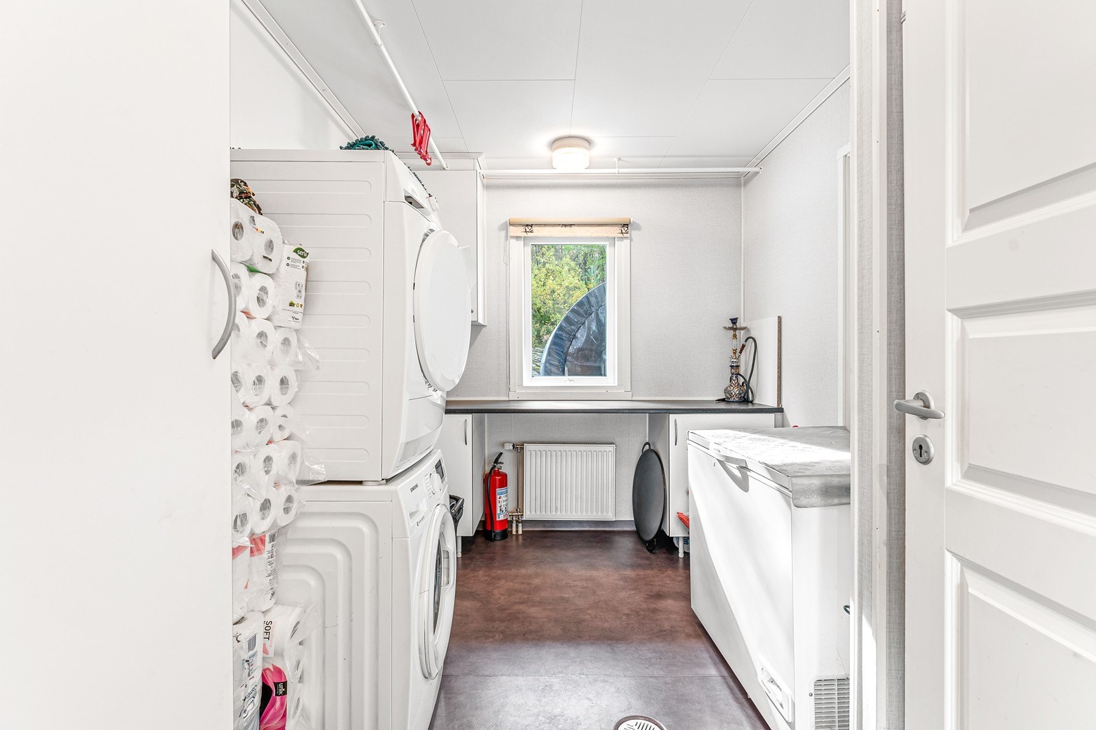 Vaskerommet er innredet med vaskemaskin, tørketrommel og utslagsvask. Galleribilde