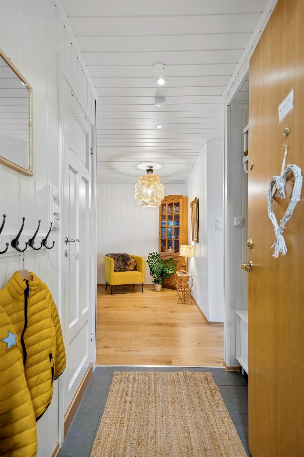 Du ønskes velkommen inn i en innbydende entré med flislagt gulv m/gulvvarme, downlights og hvitmalte veggflater Galleribilde